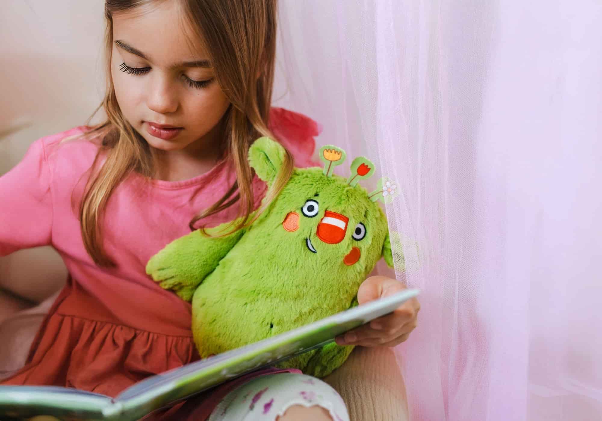 Mädchen mit Buch und das kleine WIR Plüschtier